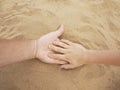 Father and son hands on sand. Close up Royalty Free Stock Photo