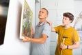 Father and son hang picture together on the wall of house Royalty Free Stock Photo