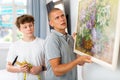 Father and son hang picture together on the wall of house Royalty Free Stock Photo