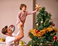 Father, son and happy with bonding by christmas tree for celebration and playing with star in the morning. Family, man Royalty Free Stock Photo