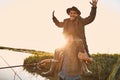 The first joint fishing of adult father and teen son in warm, sunny day. Royalty Free Stock Photo