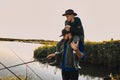 The first joint fishing of adult father and teen son in warm, sunny day. Royalty Free Stock Photo