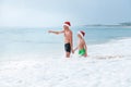 Father and son have a fun on ocean beach, wait a big waves. Christmas holiday time. Tropical vacation