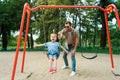 father and son having fun on swing at playground Royalty Free Stock Photo