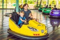 Father and son having a ride in the bumper car at the amusement park