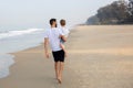 Father with son in his arms walking on a tropical beach Royalty Free Stock Photo