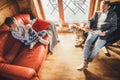 Father, son and his beagle dog spending holiday time in cozy country house. Dad reading a book, boy sitting and listening, dog Royalty Free Stock Photo