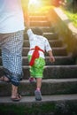 Father and son hold hands and climb the stairs. Indonesian culture. island of Bali. Close up and light