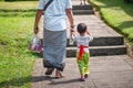 Father and son hold hands and walk together along the path. Indonesian culture. island of Bali. Close up