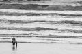 Father and son holding hands on the beach at the pacific ocean at sunset with waves Royalty Free Stock Photo