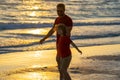 Father and son holding hands walking on sunset beach. Fathers day. Father walking with a little child son on beach near Royalty Free Stock Photo
