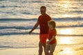 Father and son holding hands walking on sunset beach. Father and son walk in sea beach. Concept of friendly family Royalty Free Stock Photo