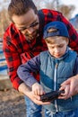 Father and son holding remote control joystick and piloting quadrocopter Royalty Free Stock Photo