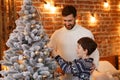 Father and son at home decorating a Christmas tree. Spending time together, relationships and people concept. Winter Royalty Free Stock Photo