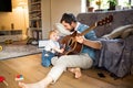 Father and son at home playing guitar together. Royalty Free Stock Photo