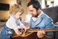 Father and son at home playing guitar together. Royalty Free Stock Photo