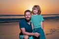 Father and son hugging on beach sunset. Happy family having fun on the sea. Royalty Free Stock Photo