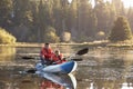 Father and son kayaking on rural lake, front view