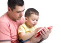 Father and son kid play with tablet computer indoors Royalty Free Stock Photo