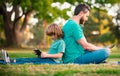 Father and son with laptop in park. Daddy teaches child use modern technology. Distance learning lesson. School