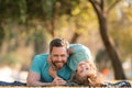 Father and son laying on grass in nature park. People having fun outdoors. Concept of happy vacation and friendly family Royalty Free Stock Photo