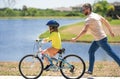 Father and son learning to ride a bicycle having fun together at Fathers day. Father teaching his son cycling on bike in Royalty Free Stock Photo