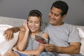 Father and Son listening to Music sitting on bed Royalty Free Stock Photo