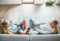 Father and son Losted in electronic devices. They playing with tablet and gamepad sitting in living room Royalty Free Stock Photo