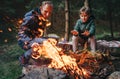 Father with son makes campfire in forest