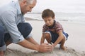 Father And Son Making Sand Castle On Beach Royalty Free Stock Photo