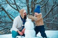 Father and son making snowman in the snow. Handmade funny snowman. Christmas holidays and winter new year with father Royalty Free Stock Photo