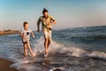 Father and son, man & boy child, running and having fun in the sand and waves of a sunny beach Royalty Free Stock Photo