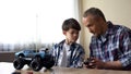 Father and son operating radio-controlled car, leisure activity, birthday gift Royalty Free Stock Photo