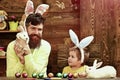 Father and son painting Easter eggs. Rabbits family with bunny ears. Royalty Free Stock Photo