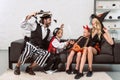 father and son in pirates costumes scaring mother and daughter on sofa Royalty Free Stock Photo