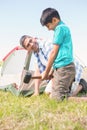 Father and son pitching their tent