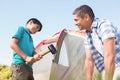 Father and son pitching their tent