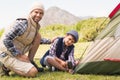 Father and son pitching their tent