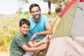 Father and son pitching their tent