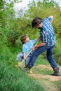 Father and son planting family tree. rich natural soil. Eco farm. Ranch. small boy child help father in farming. new