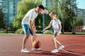 Father and son play basketball together at the basketball court. father spends time with the child, sporty lifestyle, training,