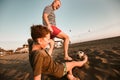 Father And Son Play Football On The Beach Having Great Family Time On Summer Holidays
