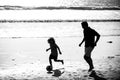 Father and son play soccer or football on the beach. Dad and child playing outdoor. Childhood and parenting concept. Royalty Free Stock Photo