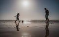 Father and son play soccer or football on the beach. Dad and child playing outdoor, silhouette on sunset. Active family Royalty Free Stock Photo