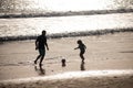 Father and son play soccer or football on the beach on summer family holidays. Dad and child having fun outdoors. Daddy Royalty Free Stock Photo