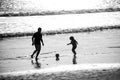 Father and son play soccer or football on the beach on summer family holidays. Dad and child having fun outdoors. Daddy Royalty Free Stock Photo