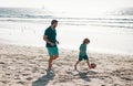 Father and son play soccer or football on the beach on summer family holidays. Dad and child playing outdoor. Royalty Free Stock Photo