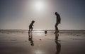 Father and son play soccer or football on the beach on summer family holidays. Daddy with kid boy playing on a summer Royalty Free Stock Photo