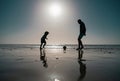 Father and son play soccer or football on the beach on summer family holidays. Daddy with kid boy playing on a summer Royalty Free Stock Photo