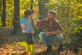 Father and son playing in the autumn forest. Little boy with his father talking in autumn outdoors. Stylish man with son Royalty Free Stock Photo